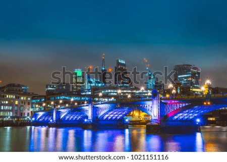 beautiful thames river at night with finance district in the background