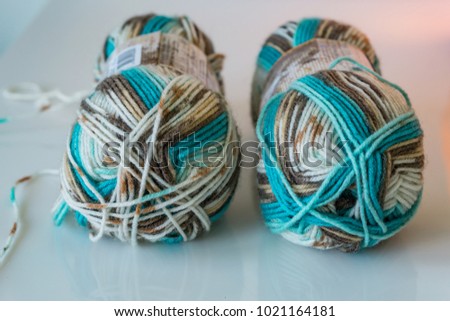 Closeup of colored yarn for knitting, skeins in blue, gray and white background, texture. Hobby concept.