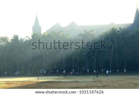 A misty morning at Oval Maidan, Mumbai, India with sports enthusiasts crowding the playground ehich is one of the biggest in south Mumbai