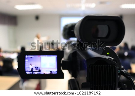 Photographer recording video lecturer and student learning by camcorder in classroom studio of university. - Education or seminar concept blur image use for background.