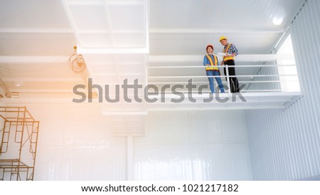Female engineers and male engineer work meeting and pointed to the painting in the site project to consult.Engineering and Construction Engineering Tools