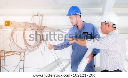 Senior Engineer explaining something to young technician, Senior Engineer pointing away at  Cable and wire. Concept engineer, technician