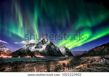 Visiting the Lofoten Islands during winter time is a dream for all landscape photographers. At this time of the year, the colourful and enchanting Aurora Borealis light up the clear night skies above Royalty-Free Stock Photo #1021223902