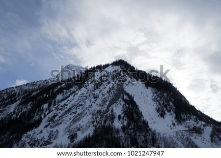 Granite mountains covered with snow and winter forest near Mont Blanc Alpes, Italy.