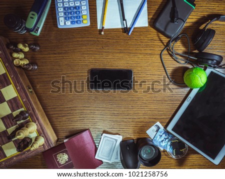mix of office supplies and gadgets on a wooden table 