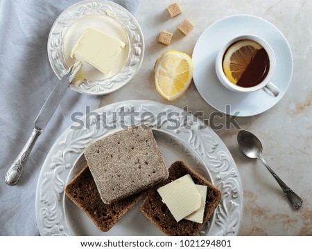 simple Breakfast - lemon tea and rye bread with butter - flat layer - top view