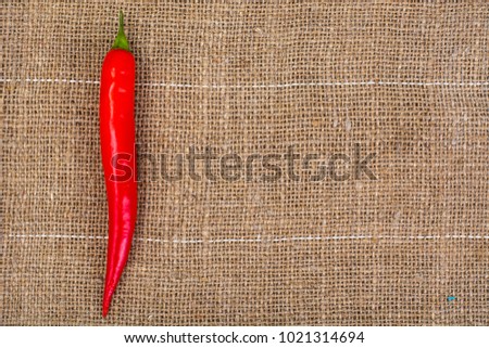 Pod of red chili peppers on fabric background. Studio Photo