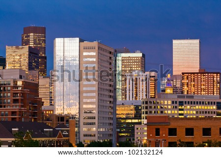 Denver skyline at dusk with colorful sunset reflection in the windows