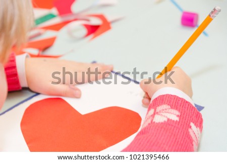 Child draw a postcard. Children are engaged in needlework. The girl signs a postcard on 14 February. St. Valentine's Day.