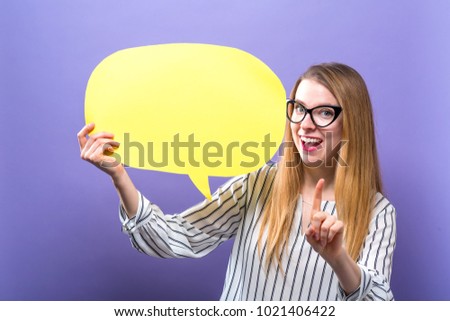 Young woman holding a speech bubble on a purple background