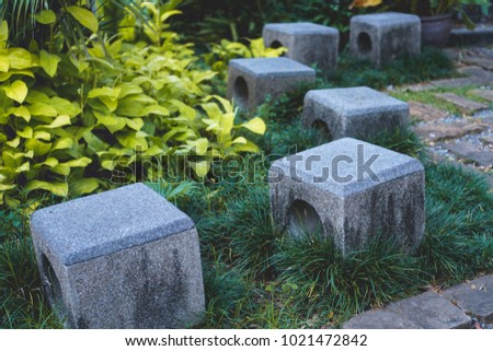Small stone stools in a beautiful tropical garden