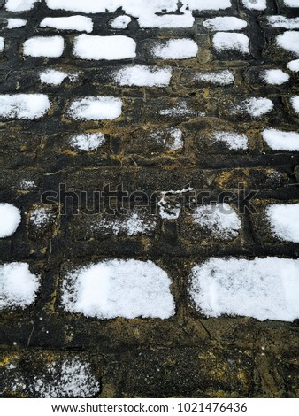 snow capped cobbled path.  this was a photo I too while walking in our town.  the cobbles on the road were capped with snow which identifies the cobbles more. 