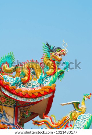 Chinese sculpture designs,Temple of China, Happy New Year of China, Temple built with splendor, golden temple, statue of serpent in front of temple, religious place, Buddhism, on blue sky background.
