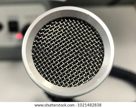 close up of microphone with background of radio transmitter in air traffic control room.