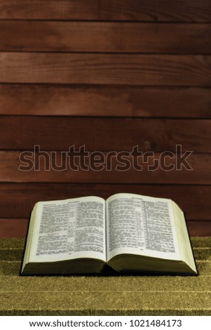 Holy Bible on a Gold table. Beautiful red wooden background.Religion concept.