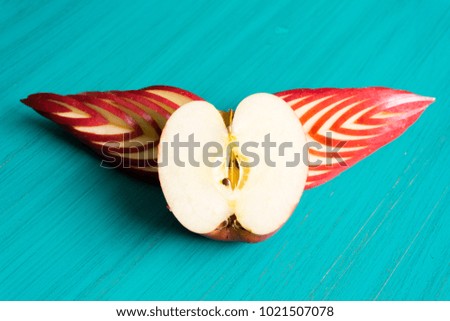 half cut red apple with sliced  like heart has wings