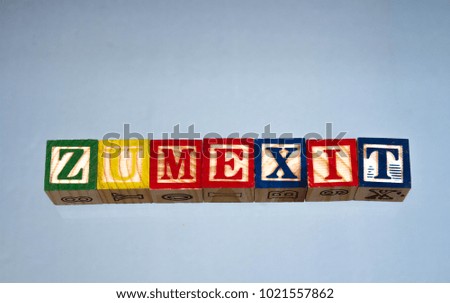 The phrase zumexit displayed visually on a light background using wooden toy blocks, image in landscape format with copy space