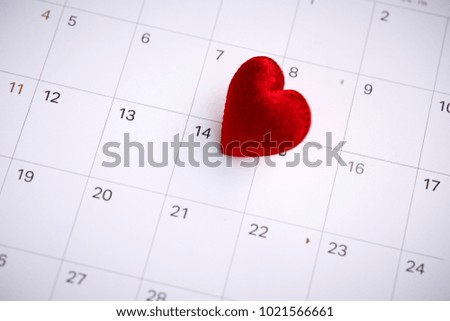 Red heart shape symbol on the February 14th date on a calendar for Valentine's Day