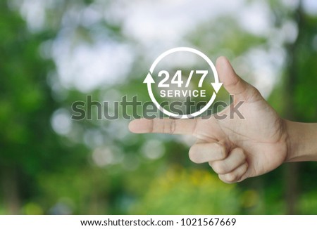 24 hours service icon on finger over blur green tree background, Full time service concept