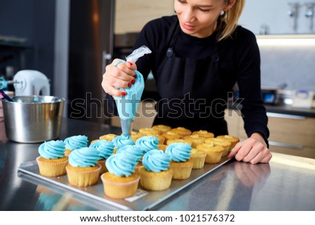 The confectioner with a pipping bag of cream in his hands decore Royalty-Free Stock Photo #1021576372
