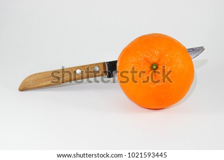 Orange and knives isolated on the skin.