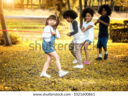 Children are happy to play tug at the park. Soft focus concept.