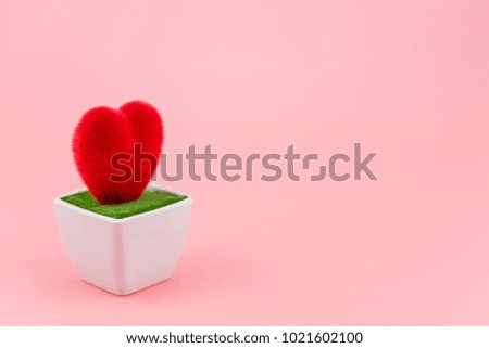 Red heart shaped on white flowerpot with pink background. Concept about love wedding and relationship, happy Valentines Day.