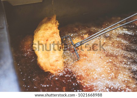 Image of haddock frying in fish and chip shop Royalty-Free Stock Photo #1021668988