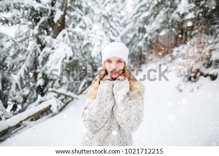 Beautiful winter portrait of young woman in the winter snowy scenery. Happy winter moments. Christmas Girl. Beautiful blond hair girl i winter clothes