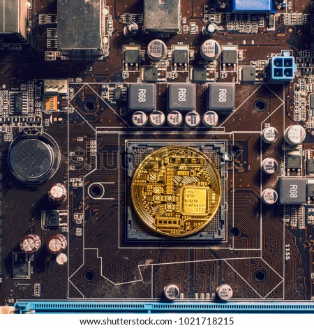  gold coin on the PC circuit board as a symbol of the production of electronic currency with Initial Coin Offering.