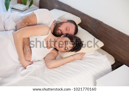 a man and a woman sleeping in beds at home