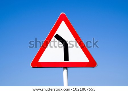 Road sign dangerous turn. Warning a sign