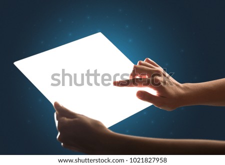 Young female hand holding and touching a piece of glass meant to look like a tablet