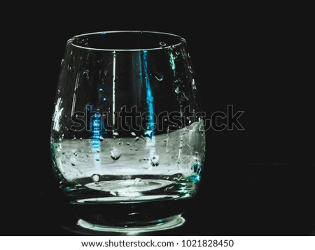 isolated glass on the table with water drops