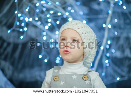 little boy in white hat on a background of blue lights
