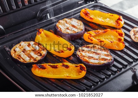 Vegetables: aubergines and yellow pepper on an electric grill. Close-up. Healthy Eating Royalty-Free Stock Photo #1021852027