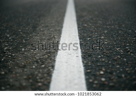 A white separation route on the gray asphalt Royalty-Free Stock Photo #1021853062