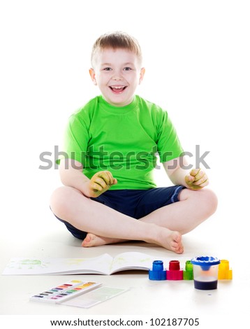a studio portrait of a nice boy drawing with watercolor paint and brush isolated on white background