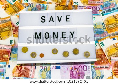 Text Save Money written on lightbox surrounded with Euro Banknotes
