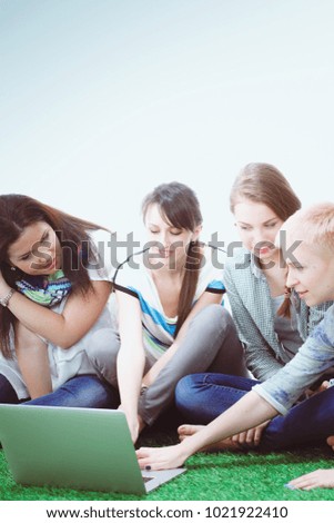 Photo of three woman sitting on grass while looking. Photo of three woman