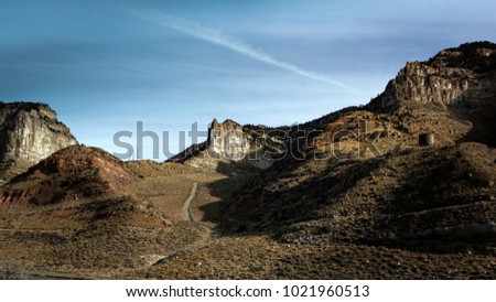 Blue skies above a desert mountain range.
