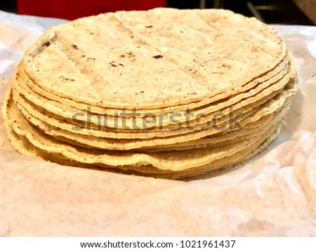 A quarter kilogram of freshly made tasty corn / maize Mexican tortillas, a staple of Mexican cuisine. Royalty-Free Stock Photo #1021961437