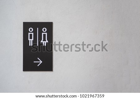 modern public toilet sign on the cement wall