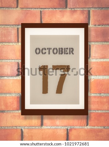 October 17th. 17 October calendar on the wood photo frame with brown brick background. Autumn day.