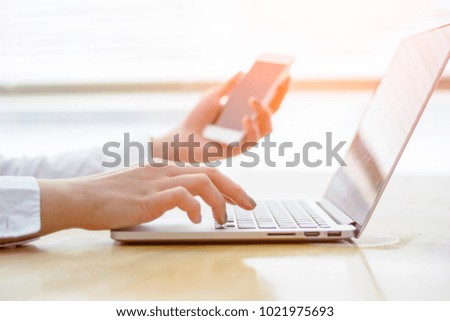Female hand  woman working with laptop computer and smartphone