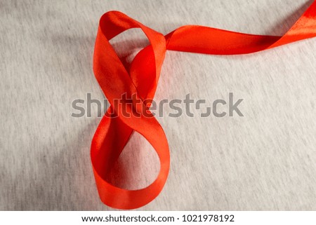 Number eight made of red red ribbon on cloth
