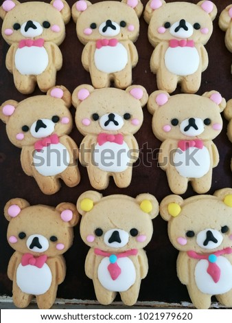 Closeup of decorated cookies in teddy bear shape on bakery tray. 