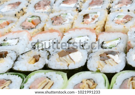 Close-up of a lot of sushi rolls with different fillings. Macro shot of cooked classic Japanese food. Background image