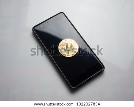 golden bitcoin on mobile phone