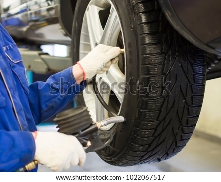 Mechanic checks the tire pressure of the car, pressure gauge, hands Royalty-Free Stock Photo #1022067517